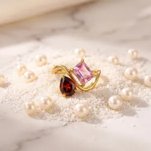 Detail shot of a gold-plated double stone ring featuring pink and red gemstones on pearls