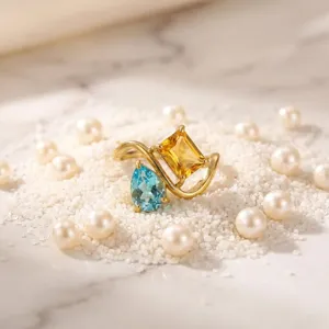 Close-up detail shot of the elegant double-stone gold plated ring with blue and yellow gems.