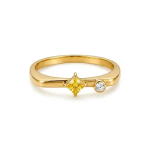 Bague plate dorée minimaliste avec une pierre jaune carrée et un petit diamant blanc.