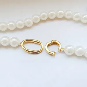 Gold metal jewelry clasp with white pearl necklace detail, DIY accessory fastener.