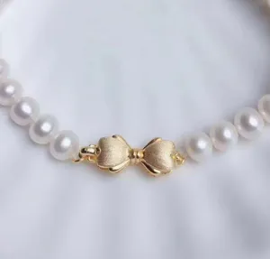 Nahaufnahme eines filigranen, goldplattierten, gebürsteten Schleifenverschlusses für Schmuck.