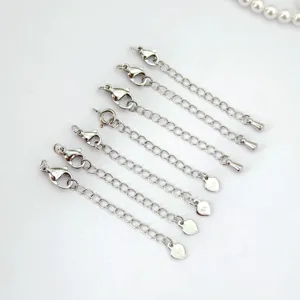 Detailed shot of silver stainless steel necklace extension chains with lobster clasps and charms.