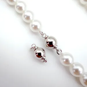 Close-up detail of a round ball screw clasp for pearl necklace or bracelet DIY crafting.