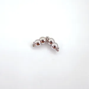 Close-up detail of curved silver magnetic clasp, metallic bead connector for jewelry.