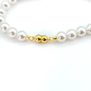 Detailed view of gold magnetic clasp for DIY pearl necklace and bracelet jewelry.