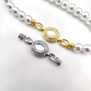 Detailed view of DIY color-retaining pearl necklace clasp, gold and silver oval mother-of-pearl connector.