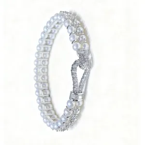 Exquisite double-row pearl bracelet detail showing a dazzling rhinestone horseshoe clasp.