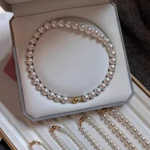 Exquisite white pearl necklace and bracelet set featuring a luxury golden magnetic ball clasp.