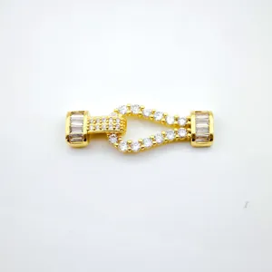 Gold-plated horseshoe jewelry clasp detail, sparkling pavé cubic zirconia decoration.