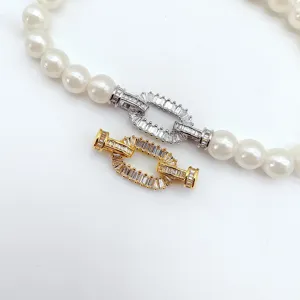 Close-up van DIY parel ketting sluiting met sprankelende vierkante zirkoon in goud zilver.
