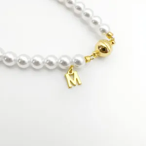 Pearl bracelet detail view with gold magnetic clasp and letter M pendant jewelry DIY accessory