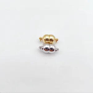 Detailed view of glossy peanut shaped magnetic jewelry clasps in gold and silver colors.