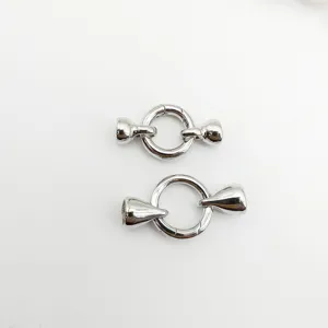 Close-up of silver metal spring ring clasps and cone ends for DIY jewelry making.