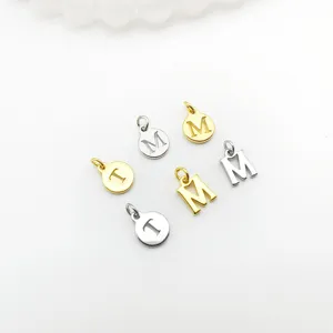 Detail shot of DIY metal letter charms, gold and silver round and 3D pendants for crafts.