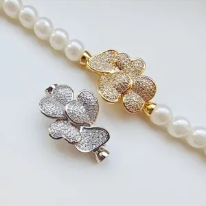 Close-up detail of shiny heart shaped pave rhinestone jewelry clasps for DIY pearl necklaces.