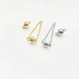 Close-up detail of metal magnetic jewelry clasps and connecting chains in gold and silver.