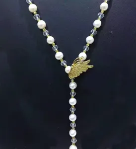 Detail shot of the gold micro-pave wing clasp accessory for pearl sweater chain necklaces.