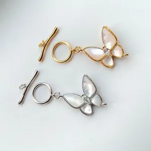 Close-up detail of butterfly shaped toggle clasps with mother of pearl and metal finish.