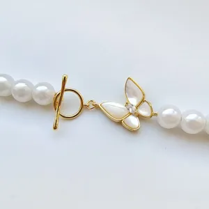 Gold-plated pearl necklace clasp with mother-of-pearl butterfly and OT toggle detail.