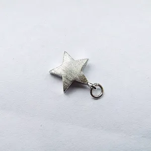 Close-up detail of silver star magnetic necklace clasp accessory, metallic texture.