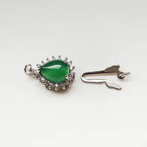 Detail shot of DIY jewelry clasp set featuring a teardrop green stone pendant and fishhook hook.