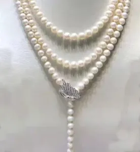 Multi-strand white pearl necklace featuring a sparkling rhinestone butterfly front clasp.