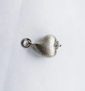 Silver heart magnetic necklace clasp detail shot showing textured matte finish and rings.