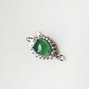 Detailed shot of DIY jewelry clasp with green teardrop stone and micro-set cubic zirconia.
