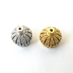 Textured metallic bead findings close up, silver and gold sphere pendant accessories detail.