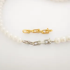 Nahaufnahme von DIY Perlenketten-Verschluss mit goldenen und silbernen U-Gliedern.