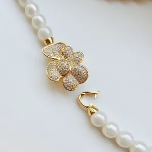 Macro detail shot of DIY pearl necklace clasp featuring zircon paved flower design.