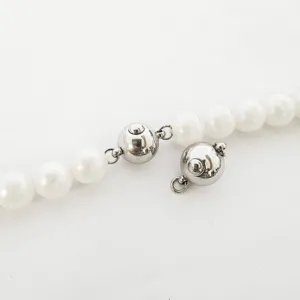 Nahaufnahme Detail der silbernen Edelstahl Kugelverschluss und weiße Perlen für DIY Schmuck.