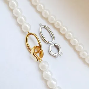 Close up of pearl necklace details with gold and silver interchangeable oval clasps connectors.