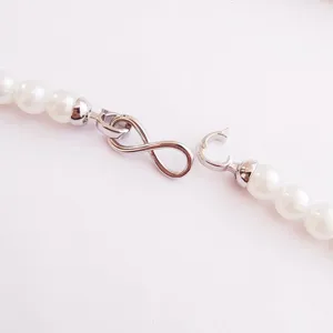 Nahaufnahme Detail silberfarbener Unendlichkeitsverschluss mit weißen Perlen für DIY Schmuck.
