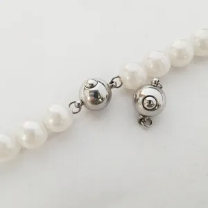 Detailaufnahme eines runden Edelstahl Kugelverschlusses für Perlenketten und DIY Schmuck.