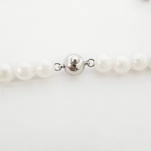 Nahaufnahme des silbernen Kugelverschlusses an weißer Perlenkette, DIY Schmuckteil.