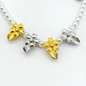 Close-up detail of the brushed gold and silver flower leaf pearl necklace clasp buckle.