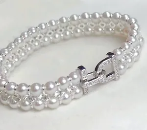 Double row pearl bracelet with sparkling zircon metal clasp, delicate jewelry accessory design.