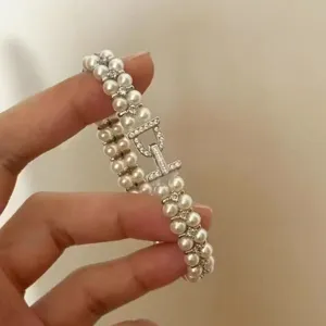Detailed view of a double-row pearl bracelet with sparkling zircon CD logo clasp.