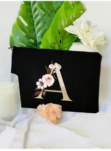 Bolsa de maquillaje negra de lona con letra A dorada y diseño floral para uso diario.