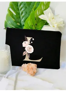 Elegante neceser de maquillaje de terciopelo negro con letra floral L para el almacenamiento diario.