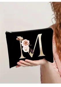 Bolso de maquillaje de lona negra con letra M dorada y flores, elegante neceser para mujer.