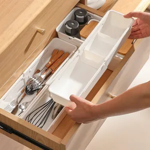 Expandable kitchen drawer organizer white plastic cutlery tray with adjustable compartments.