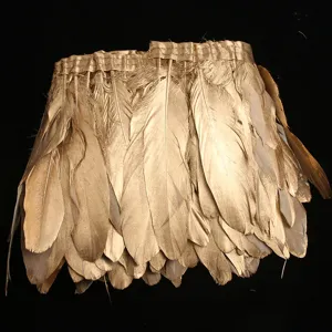 Close up of gold feather trim ribbon fringe, perfect for DIY garment sewing and home decor details.