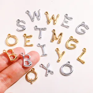 Gros plan sur les pendentifs lettres alphabet en métal DIY avec strass pour fabrication.