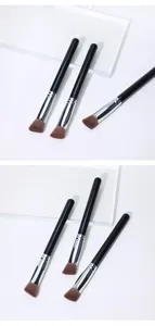 Close-up detail of triangular makeup brushes, highlighting concealer brush with soft bristles.