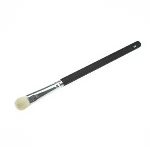 Detail shot of black wooden handle eyeshadow makeup brush with soft animal hair bristles.