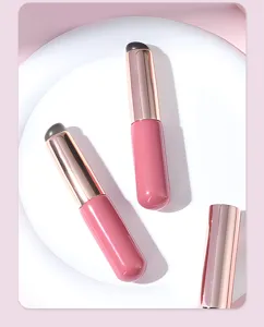 Detailweergave van de draagbare siliconen lipkwast, zacht make-up hulpmiddel met dop roze goud.
