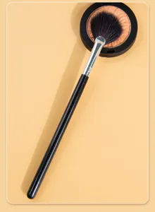 Small fan-shaped highlighter brush soft makeup tool for precise facial contouring and glow.