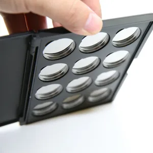 Detailansicht der leeren magnetischen Lidschattenpalette mit zwölf runden Metallpfännchen.